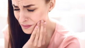 tooth pain woman holding her jaw in pain