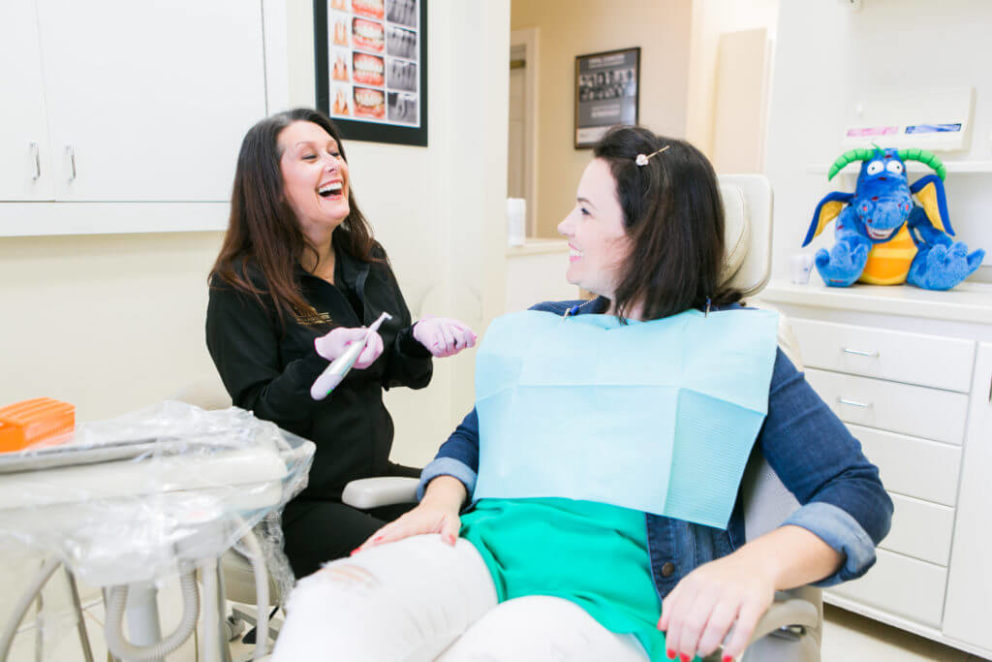 Hygienist laughing with her patient before applying prophy