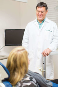 Raleigh Neuse doctor talking to patient in chair about cosmetic dentistry services in Raleigh NC