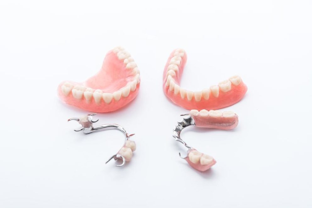 dentures and partials laid on white surface