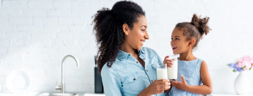 mom and daughter laughing while drinking milk