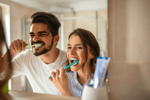 couple brushing their teeth at same sink