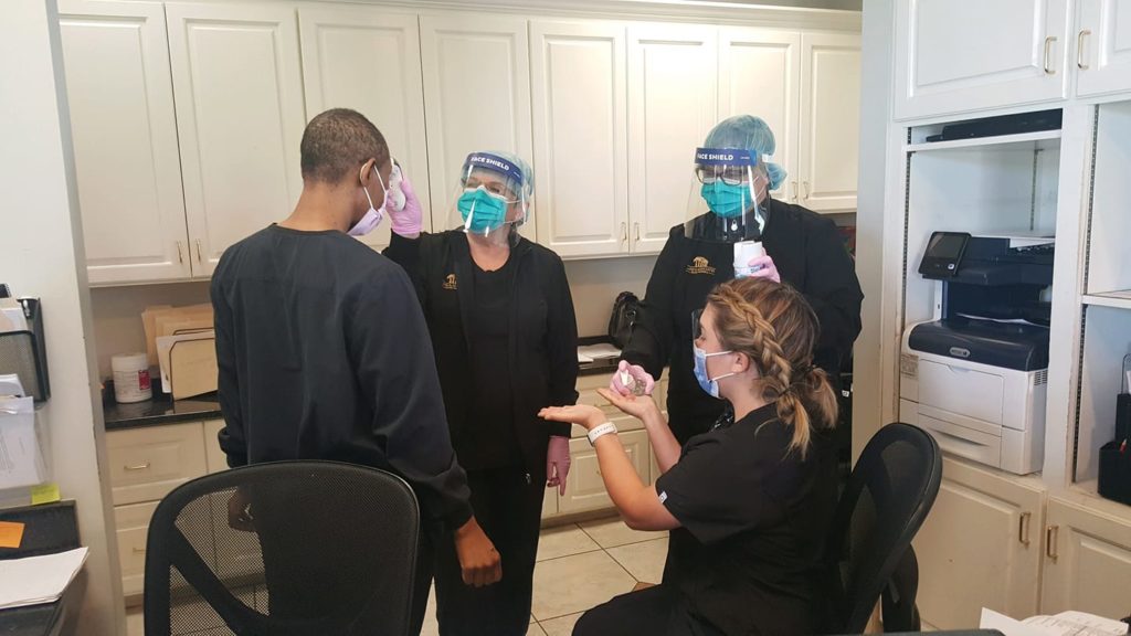 LAA staff putting on hand sanitizer and checking temperatures