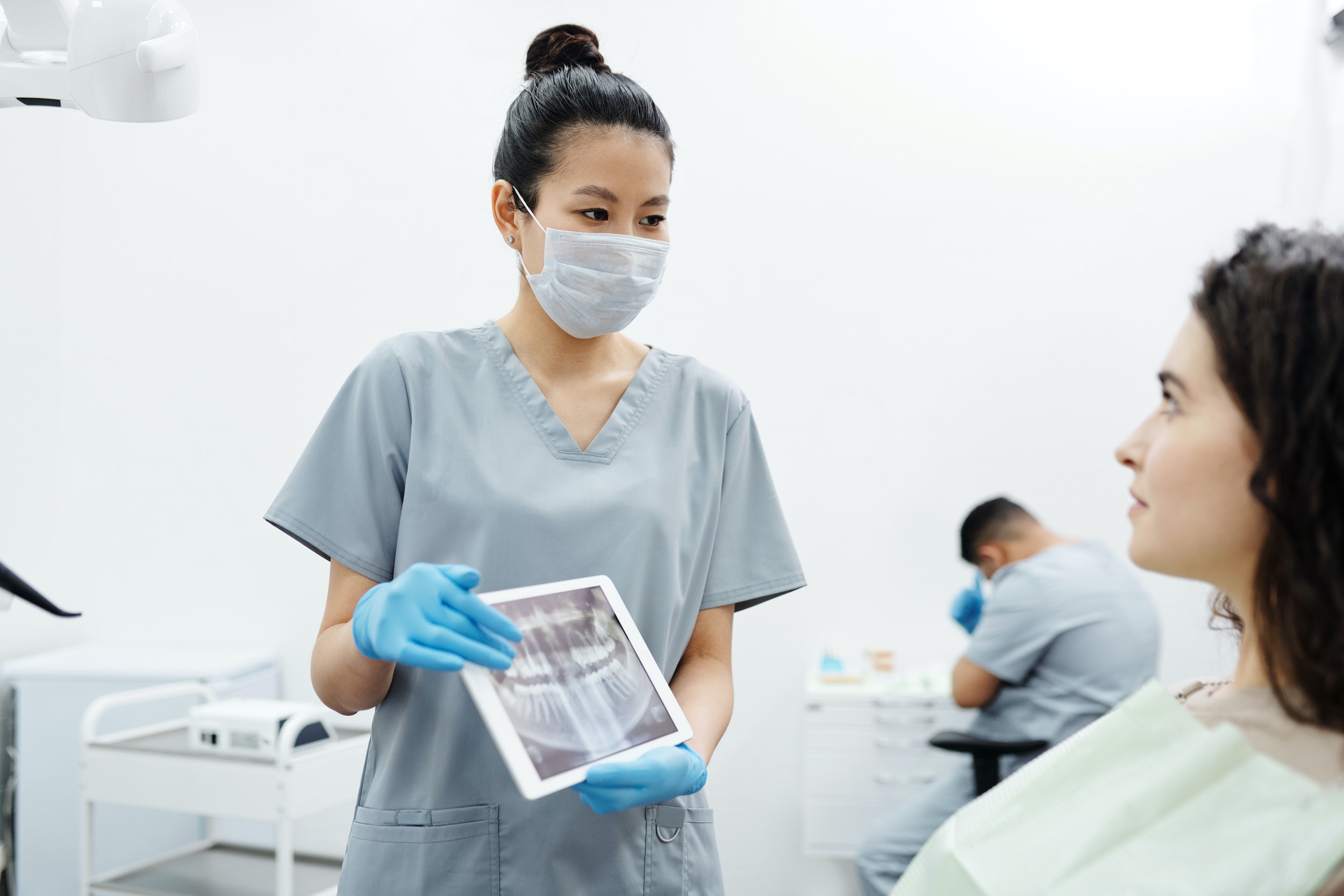 dentist holding x ray up to patient